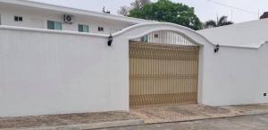 a white fence with a wooden garage door at VILLAS MARQUIS in Ciudad Valles