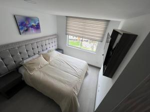 Dormitorio pequeño con cama y TV en Edificio apartamentos central con ascensor 502, en Bogotá
