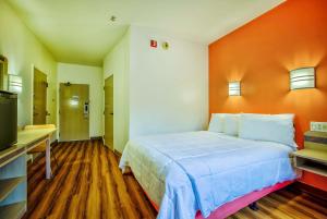 Un dormitorio con una cama grande con una pared naranja. en Motel 6-Burlington, ON - Toronto West - Oakville, en Burlington