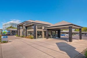 een winkelcentrum met een gebouw op een parkeerplaats bij Best Western New Oregon Motel in Eugene