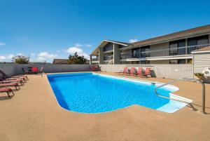 einen Pool mit Stühlen und ein Gebäude in der Unterkunft Best Western University Inn in Murray