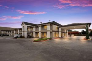 a large building with a parking lot in front of it at SureStay Hotel by Best Western Deer Park in Deer Park