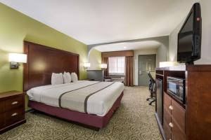 a hotel room with a bed and a flat screen tv at SureStay Hotel by Best Western Deer Park in Deer Park