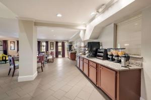 a large kitchen with a counter and a living room at SureStay Hotel by Best Western Deer Park in Deer Park