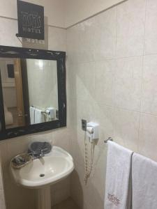 y baño con lavabo, espejo y toallas. en Motel isis en Guadalajara