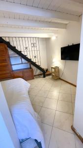 Habitación con cama, TV y escalera. en Departamento Centro Bariloche 2/3/4/6 Pax en San Carlos de Bariloche