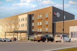 a large building with cars parked in a parking lot at Best Western Plus Dauphin in Dauphin