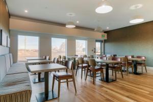 a dining room with tables and chairs and windows at Best Western Plus Dauphin in Dauphin