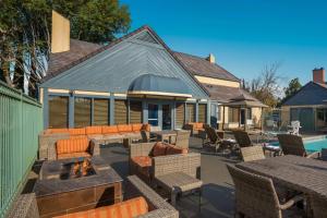 een gemeubileerde patio en een open haard naast een zwembad bij SenS Suites Livermore; SureStay Collection by Best Western in Livermore