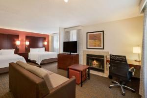 a hotel room with two beds and a fireplace at SenS Suites Livermore; SureStay Collection by Best Western in Livermore