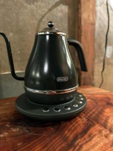 a black tea kettle sitting on top of a wooden table at 淡路島 サササウナ in Awaji