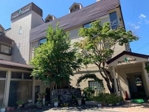 富士河口湖的住宿－Kawaguchiko Park Hotel，前面有树木的建筑