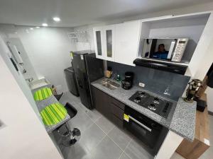 cocina con fregadero y fogones horno superior en Aparta estudios central Con ascensor 503, en Bogotá