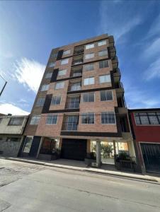 un edificio alto de ladrillo en una calle de la ciudad en Aparta estudios central Con ascensor 503, en Bogotá