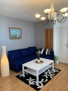 a living room with a blue couch and a table at Biarritz centre bel Apt 2 pièces rue calme in Biarritz
