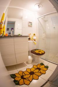 a bathroom with a toilet and a shower with a flower rug at Apartamento Mari 1 in São Carlos