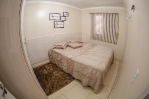 um quarto com uma cama num pequeno quarto em Apartamento Mari 1 em São Carlos