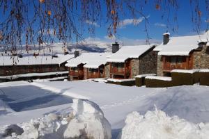 Chalet à Nahuja في Nahuja: تكدس الثلج امام مجموعة منازل