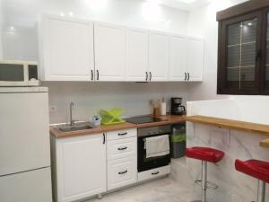 una cocina con armarios blancos y fregadero en HELLO HOME FERIA, en Madrid