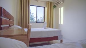 a bedroom with two beds and a window at Speed 8 Inn Moalboal in Moalboal