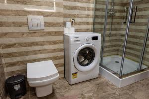 bagno con lavatrice e servizi igienici di Adonis Albu's Residence a Braşov