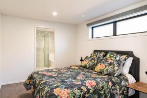 a bedroom with a bed and a window at Blue House on the Quay in Motueka