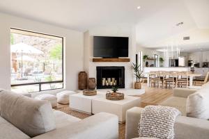 a living room with white furniture and a fireplace at NEW Experience Base Camp An Exclusive Mountainside Desert Resort with 2 Pools in Palm Desert
