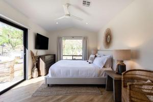 a bedroom with a bed and a large window at NEW Experience Base Camp An Exclusive Mountainside Desert Resort with 2 Pools in Palm Desert +104 photos