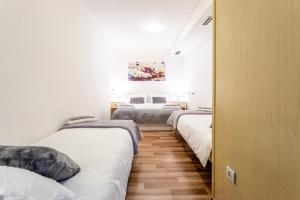 a row of beds in a room with white walls at Studio apartment Negi in Split