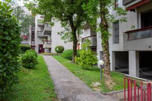 a walkway in front of a building with trees at Rucellai Guest House in Milan