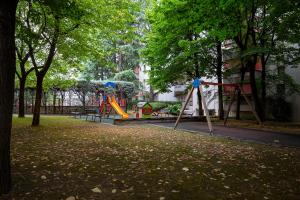 a park with a playground with slides and trees at Rucellai Guest House in Milan