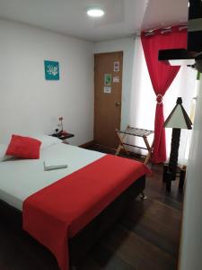 a bedroom with a large bed with a red blanket at Posada San Nicolas in San Andrés
