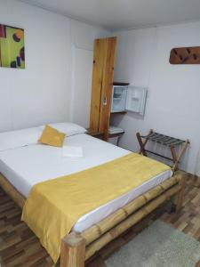 Posada San Nicolas في سان أندريس: غرفة نوم بسرير كبير مع بطانية صفراء