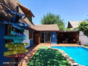 a house with a sign next to a swimming pool at Maktub Costanera - Hostal Boutique in Santiago