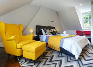 シドニーにあるKent Terraceのベッドルーム1室(ベッド2台、黄色い椅子付)
