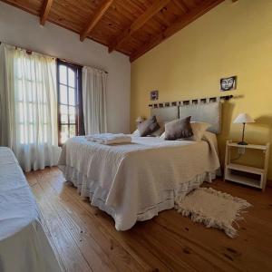 a bedroom with a large bed with white sheets at Hosteria Isabel in Las Grutas