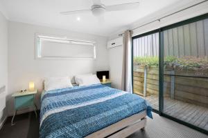a bedroom with a bed and a balcony at Questa E Bella in Lorne