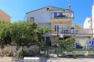 un edificio blanco con una valla delante en Apartments by the sea Businci, Ciovo - 9450, en Trogir