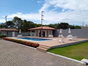 um pátio com uma piscina e cadeiras e um edifício em APARTAMENTO 3 quartos no Taperapuan Duplex 450 mt da praia em Porto Seguro