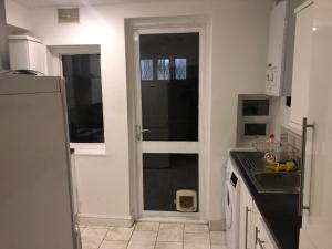 a kitchen with a door with a sink and a counter at Common 2 in London