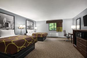 Cette chambre comprend deux lits et un bureau. dans l'établissement Super 8 by Wyndham Grove City, à Grove City
