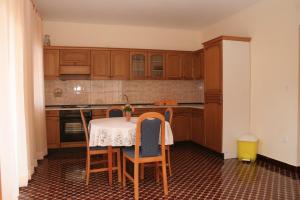 eine Küche mit einem Tisch mit Stühlen und einem Waschbecken in der Unterkunft Apartments by the sea Orebic, Peljesac - 10436 in Orebić