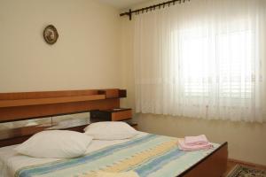 a bedroom with a large bed with a window at Apartments by the sea Orebic, Peljesac - 10436 in Orebić