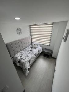 a small bedroom with a bed and a window at Edificios de apartamentos central con ascensor 604 in Bogotá