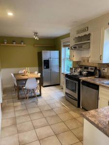 a kitchen with a table and a stainless steel refrigerator at Cosy 5 Bedrooms House in Hearth of Richmond Hill in Richmond Hill