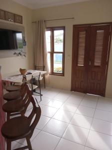eine Küche mit einem Tisch und Stühlen sowie einem Fenster in der Unterkunft APARTAMENTO 3 quartos no Taperapuan Duplex 450 mt da praia in Porto Seguro