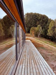 a porch of a house with a wooden deck at Refugio Pullao in Quilquico