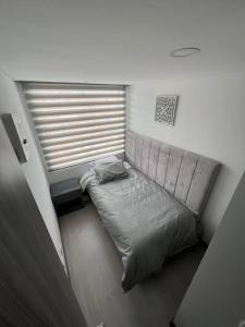 a small bed in a room with a window at Edificio Apartamentos central con ascensor 605 in Bogotá