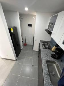 a small kitchen with a sink and a refrigerator at Edificio Apartamentos central con ascensor 605 in Bogotá