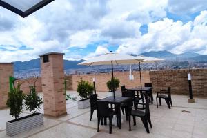 a patio with tables and chairs and an umbrella at Edificio Apartamentos central con ascensor 605 in Bogotá